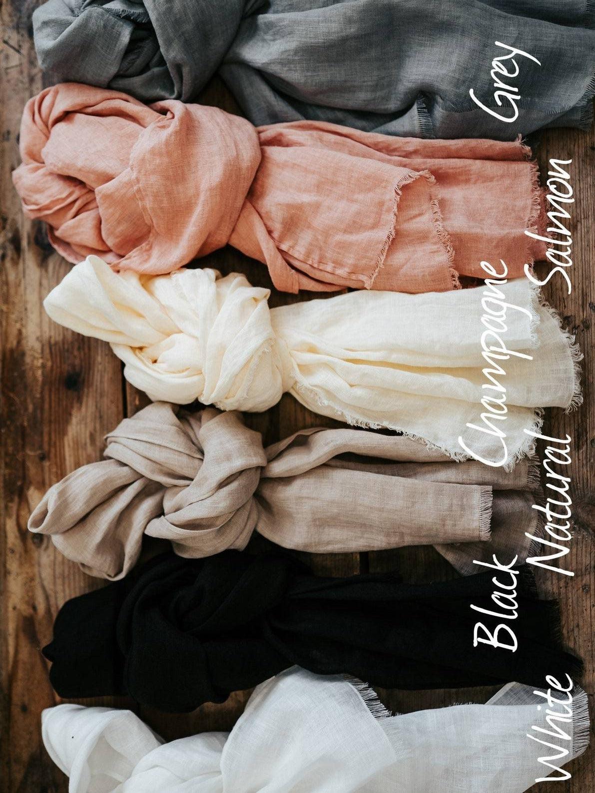 linen scarves in various colors tied in a knot on a rustic table